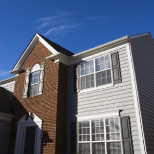Home with brick front, grey siding, and white windows