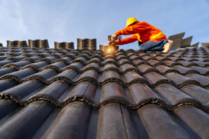 Worker installing roof shingles on a home